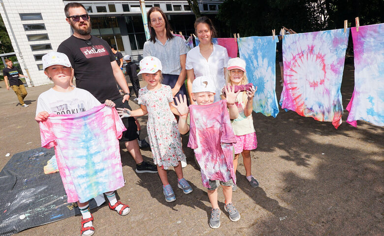 Stefan Bartizal vom Sozialamt (v.l.), Daniela Bockholt und Nina Klaus vom Jugendamt helfen mit, wenn die Kinder bei der Stadtranderholung bunte Batik-T-Shirts gestalten.