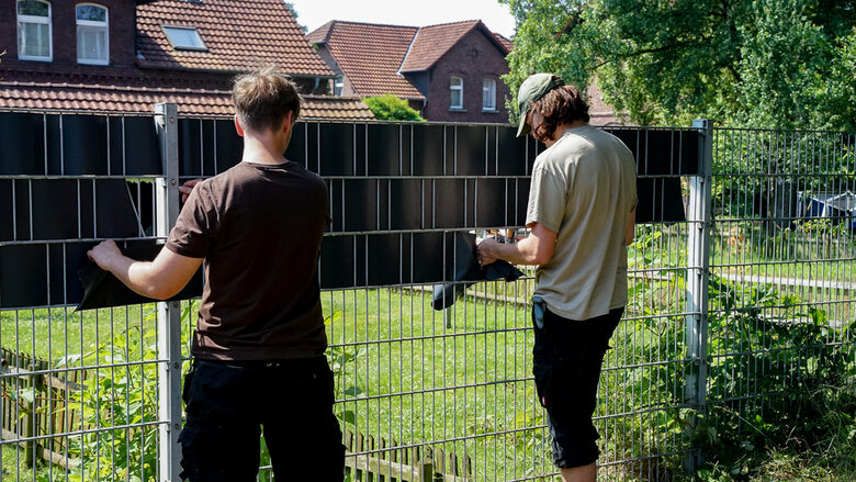 Zwei Schüler setzen Sichtschutz